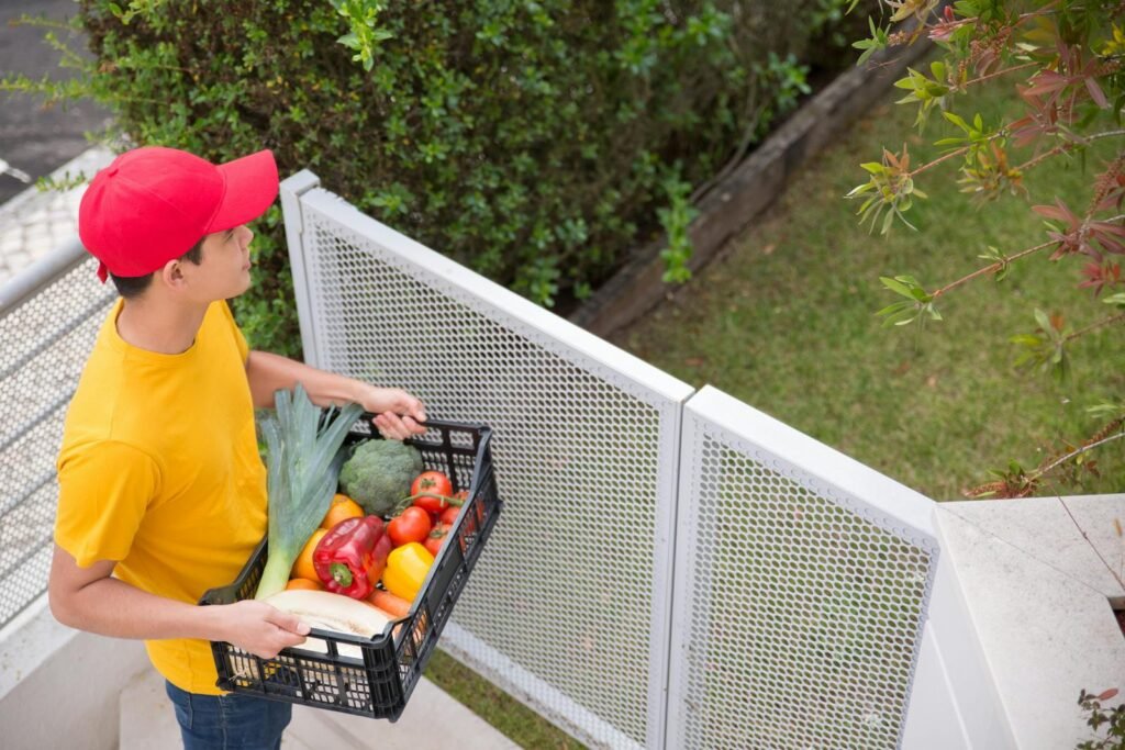 Transportista Vaca Valdemoro Young man carrying a crate of fresh vegetables outdoors in Portugal garden.